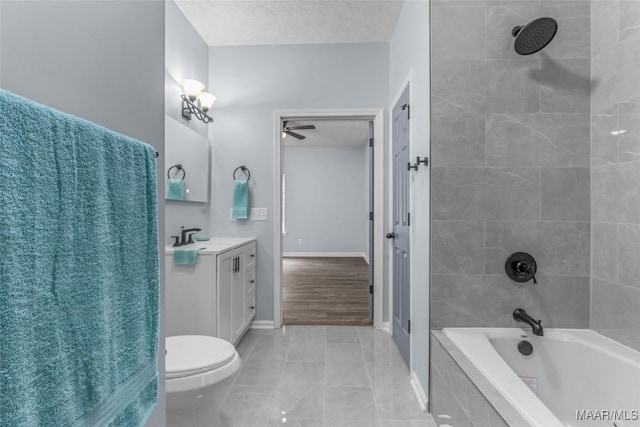 full bathroom featuring tiled shower / bath, vanity, toilet, tile patterned floors, and a textured ceiling