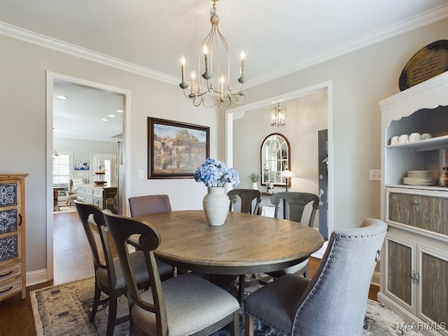 dining area featuring crown molding, dark hardwood / wood-style floors, and a chandelier