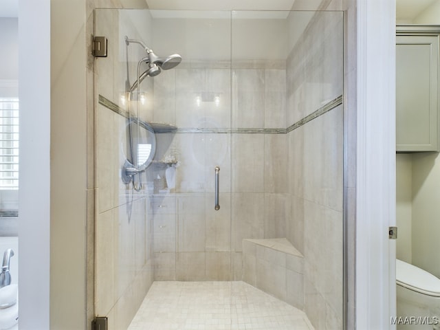 bathroom featuring toilet and a shower with shower door