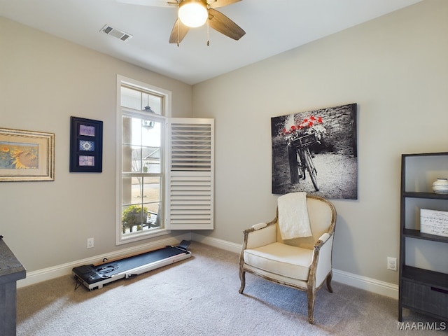 living area with ceiling fan and carpet