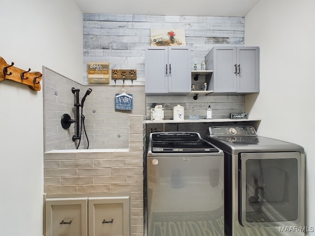 laundry room with washer and clothes dryer and cabinets