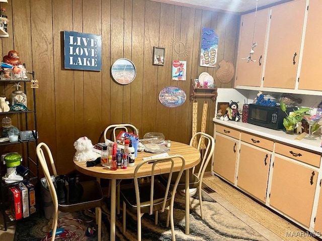 dining area featuring light wood-type flooring and wood walls