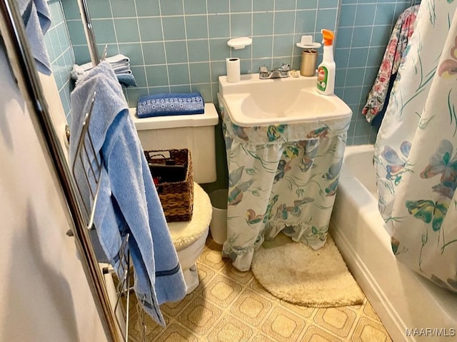 bathroom featuring shower / bathtub combination with curtain, tile patterned flooring, tile walls, and toilet