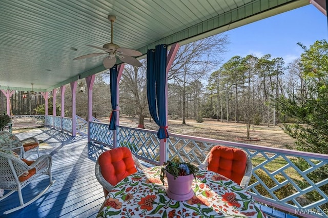 wooden terrace with ceiling fan and covered porch