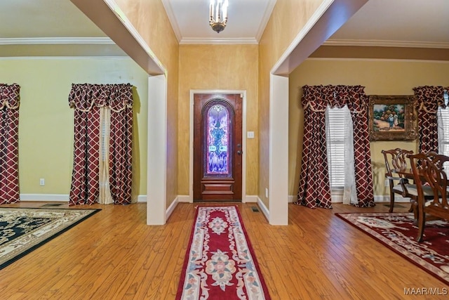 foyer featuring crown molding and light hardwood / wood-style flooring