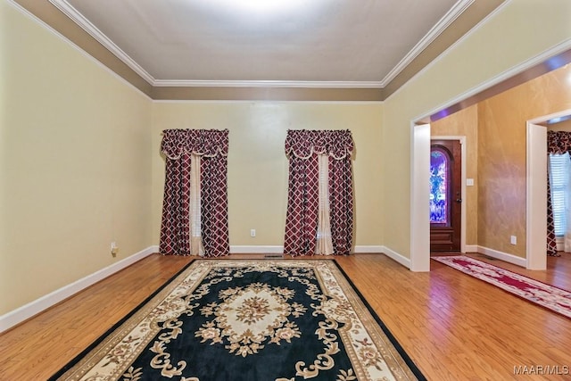 foyer with wood-type flooring and crown molding