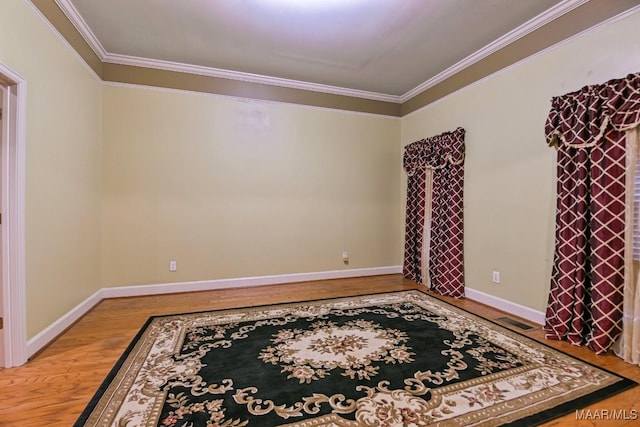 unfurnished room with hardwood / wood-style flooring and ornamental molding