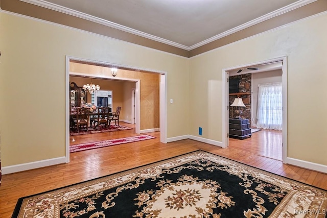 hall featuring hardwood / wood-style flooring, ornamental molding, and a notable chandelier