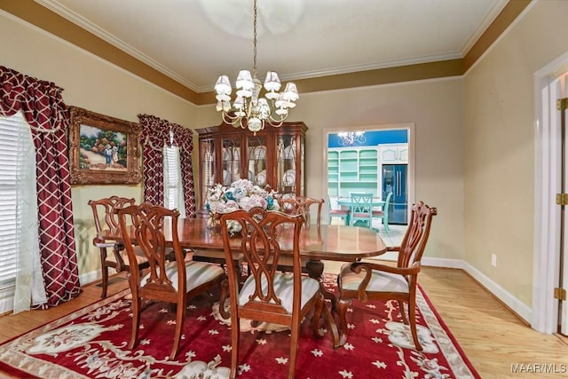 dining room with hardwood / wood-style floors, crown molding, and a chandelier