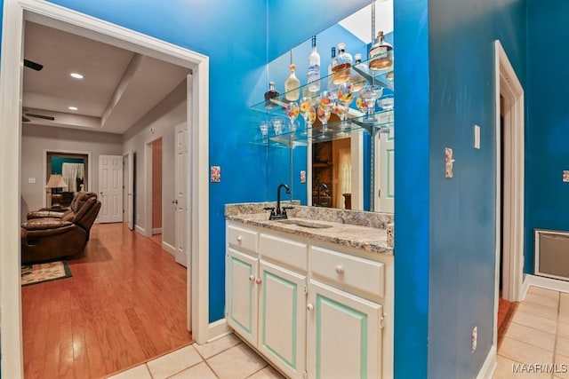 bathroom featuring a raised ceiling, vanity, and tile patterned floors