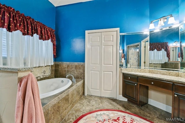 bathroom featuring vanity and a relaxing tiled tub