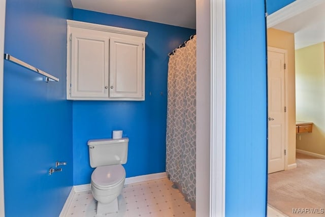 bathroom with curtained shower and toilet