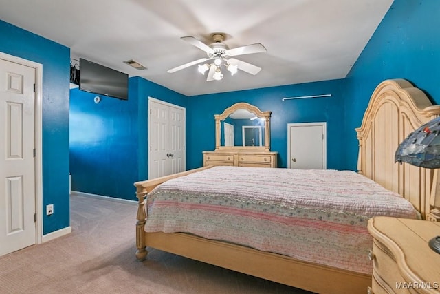 carpeted bedroom with ceiling fan and a closet