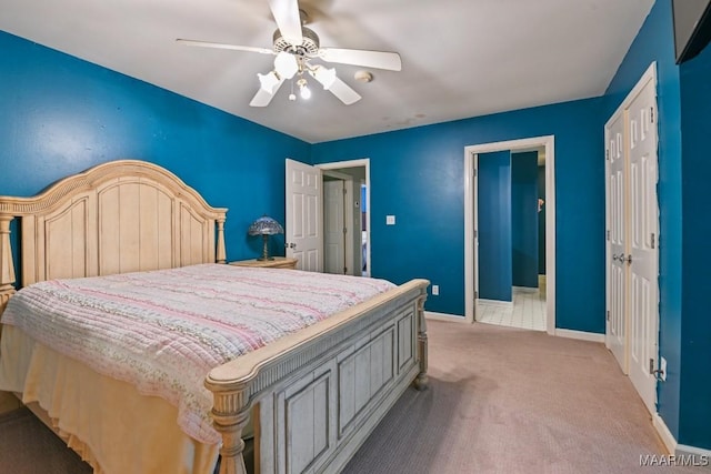 carpeted bedroom featuring ceiling fan and ensuite bath