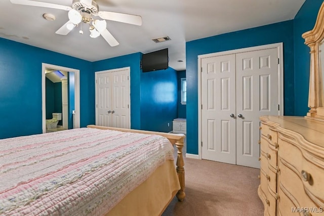 carpeted bedroom featuring two closets and ceiling fan