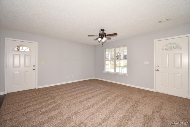 foyer entrance with ceiling fan, carpet flooring, and a textured ceiling