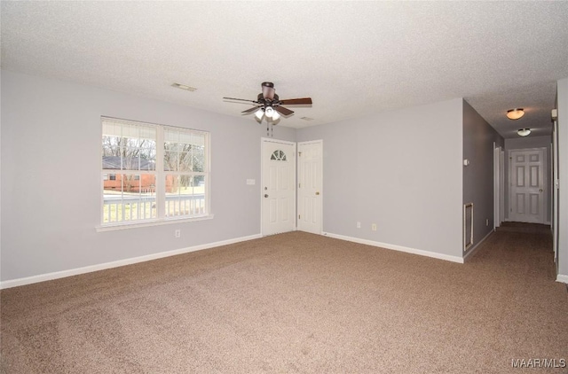 empty room featuring ceiling fan, carpet, and a textured ceiling