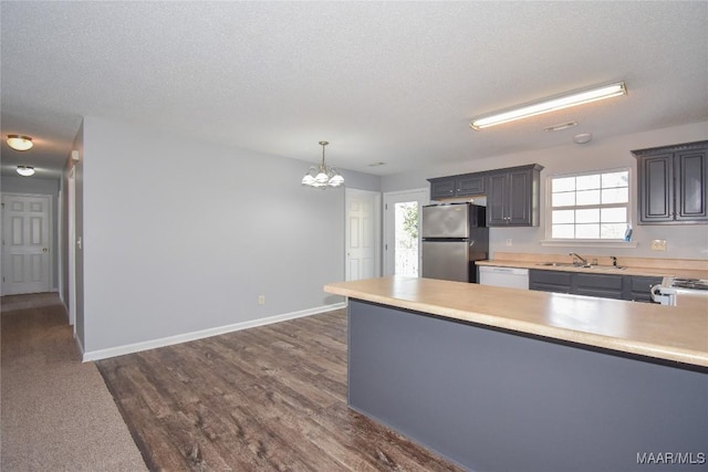 kitchen with white dishwasher, decorative light fixtures, stainless steel fridge, and a textured ceiling