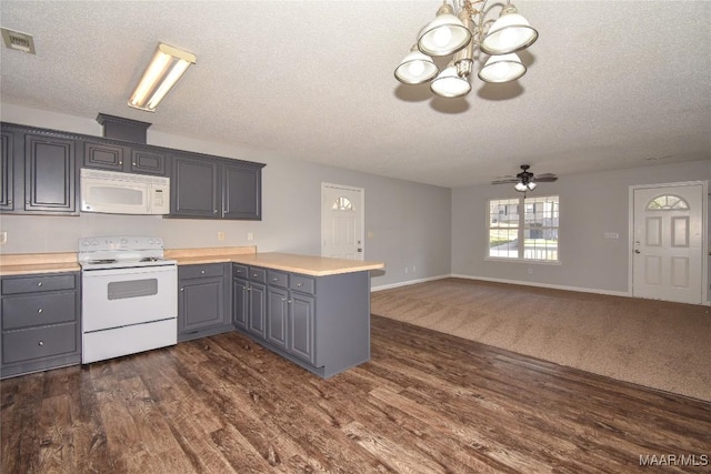 kitchen featuring gray cabinets, dark hardwood / wood-style flooring, white appliances, and kitchen peninsula