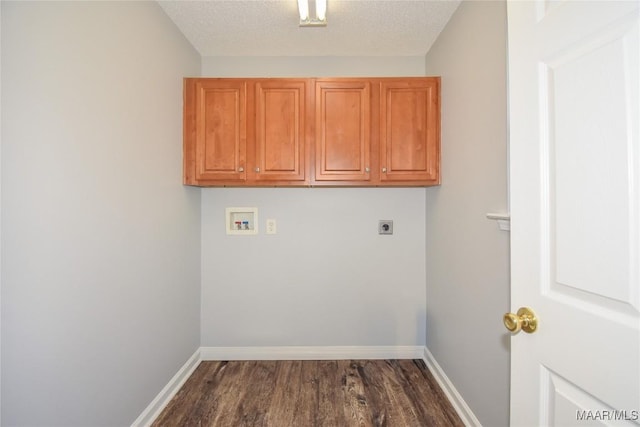 laundry area featuring electric dryer hookup, hookup for a washing machine, cabinets, dark hardwood / wood-style floors, and a textured ceiling