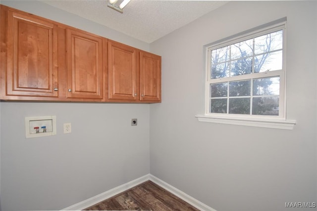 laundry room with cabinets, a textured ceiling, dark hardwood / wood-style flooring, electric dryer hookup, and washer hookup