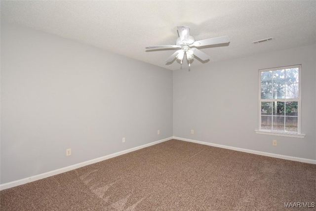 carpeted spare room featuring ceiling fan and a textured ceiling