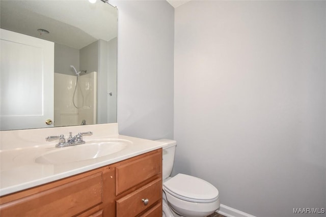 bathroom with vanity, toilet, and a shower