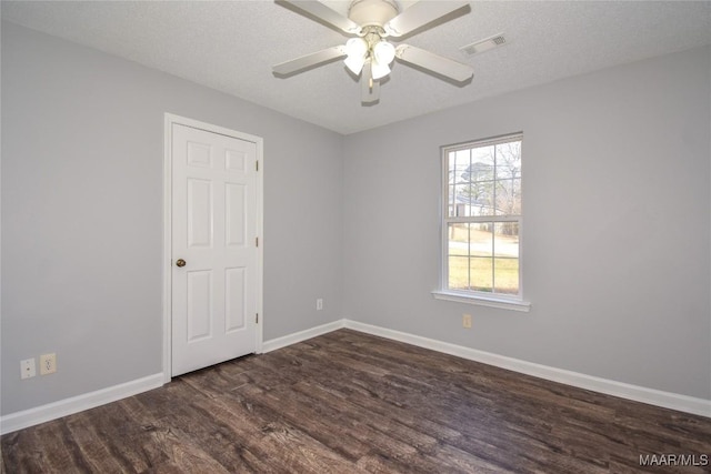 unfurnished room with dark hardwood / wood-style flooring, a textured ceiling, and a healthy amount of sunlight