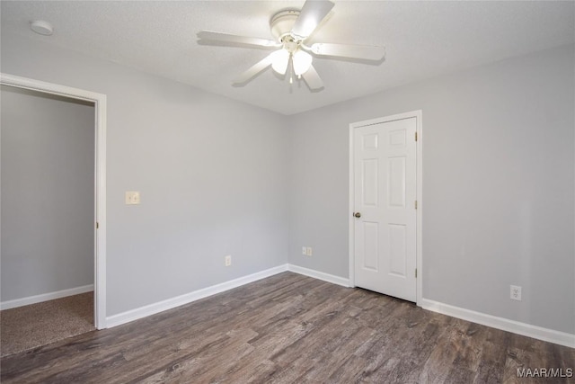 spare room with dark hardwood / wood-style floors, a textured ceiling, and ceiling fan