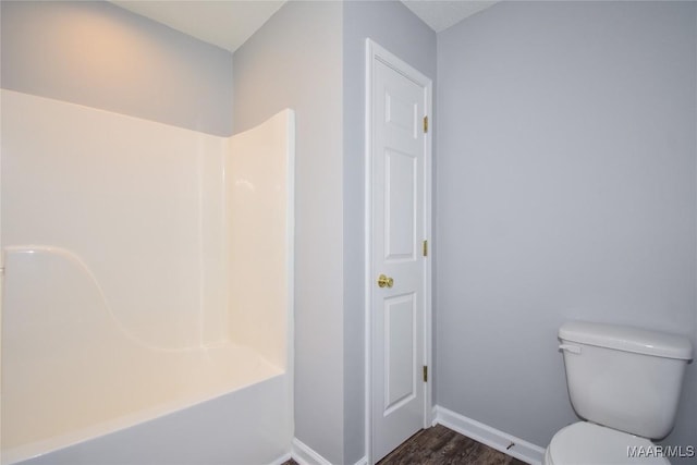 bathroom featuring hardwood / wood-style flooring, shower / tub combination, and toilet