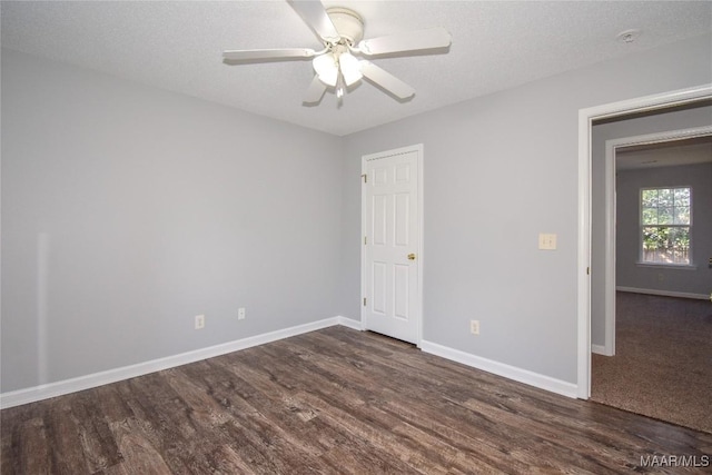 unfurnished room with ceiling fan, dark wood-type flooring, and a textured ceiling