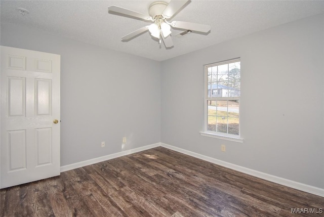 spare room featuring ceiling fan, dark wood-type flooring, and a textured ceiling