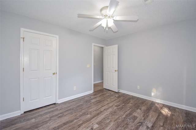 unfurnished room with dark wood-type flooring, a textured ceiling, and ceiling fan