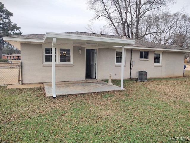 rear view of house featuring a patio, central AC, and a lawn