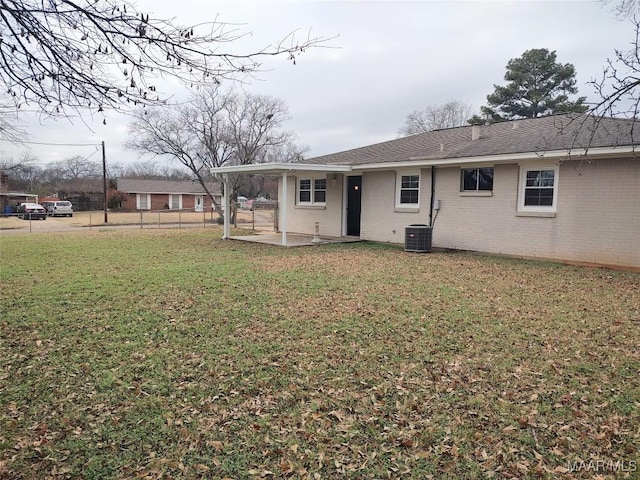 rear view of property featuring a yard, central air condition unit, and a patio area