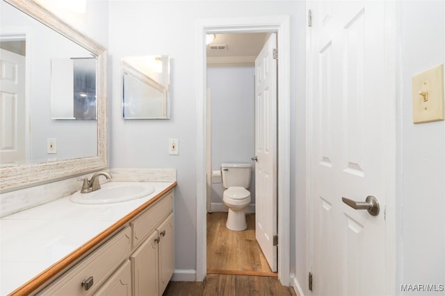 bathroom with hardwood / wood-style flooring, vanity, and toilet