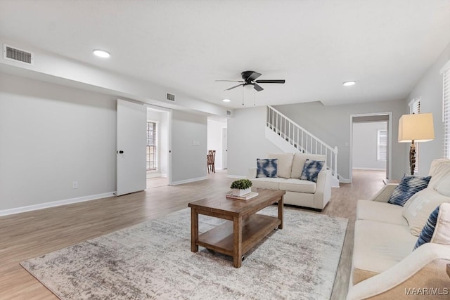 living room with ceiling fan and light wood-type flooring