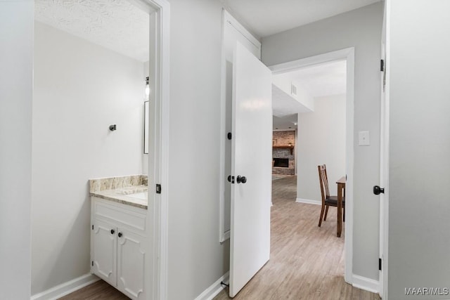 bathroom featuring vanity, hardwood / wood-style flooring, and a fireplace