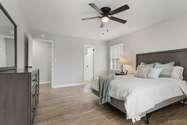 bedroom featuring a textured ceiling, light hardwood / wood-style floors, and ceiling fan