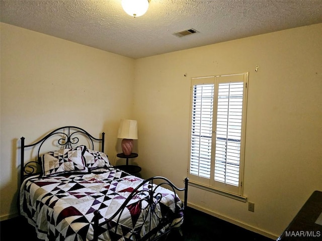 bedroom with multiple windows and a textured ceiling