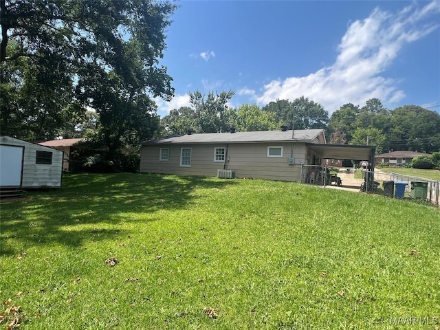 rear view of house featuring a storage unit and a lawn