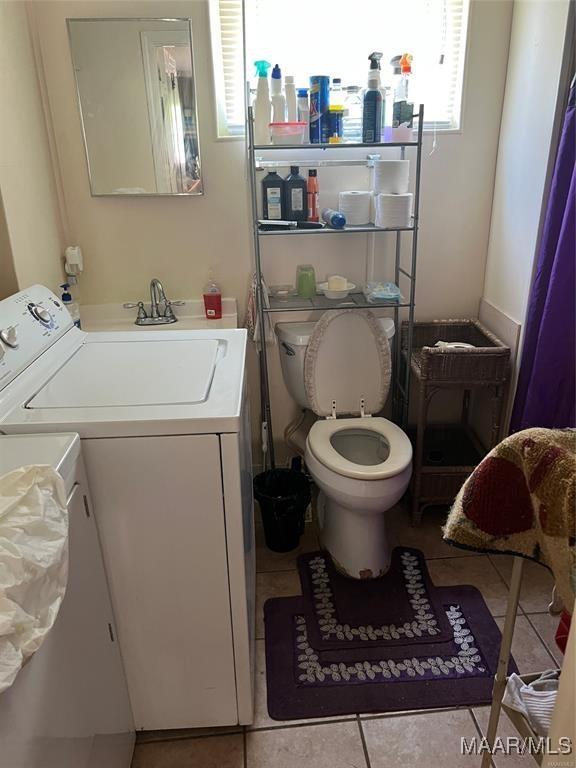 bathroom with vanity, separate washer and dryer, tile patterned floors, and toilet