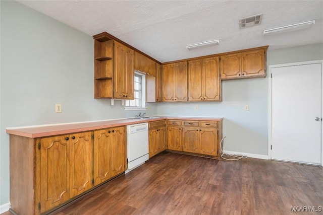 kitchen with sink, a textured ceiling, dark wood-type flooring, and dishwasher