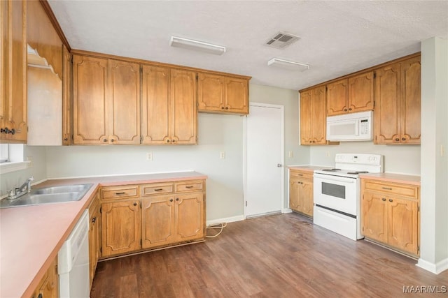 kitchen with white appliances, dark hardwood / wood-style flooring, sink, and a textured ceiling