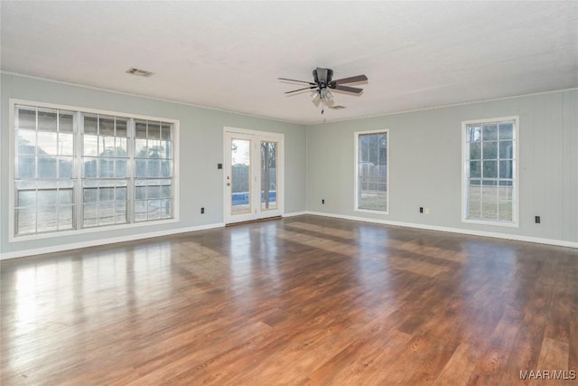 unfurnished living room with dark hardwood / wood-style flooring and ceiling fan