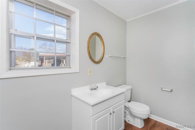 bathroom with vanity, wood-type flooring, crown molding, and toilet