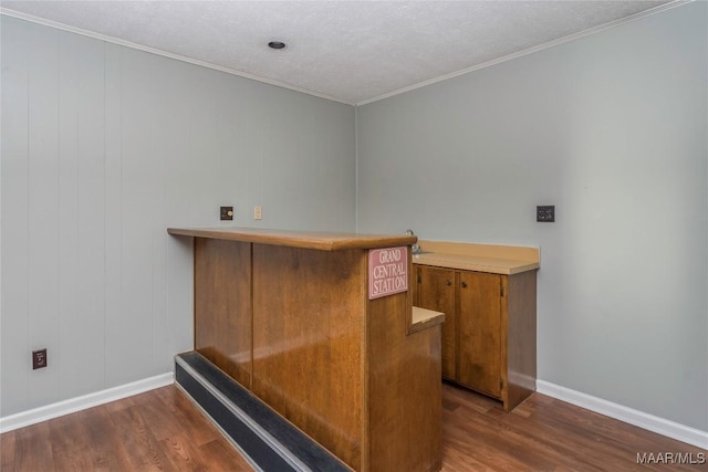 office with dark wood-type flooring, ornamental molding, bar, and a textured ceiling