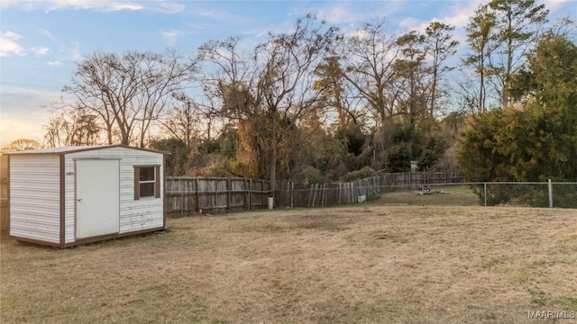 yard at dusk featuring a storage unit