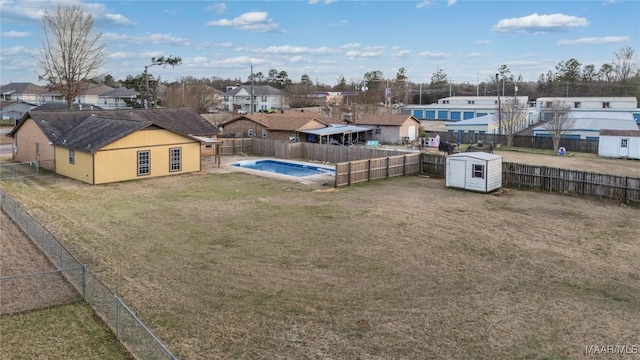 view of yard featuring a storage shed and a fenced in pool