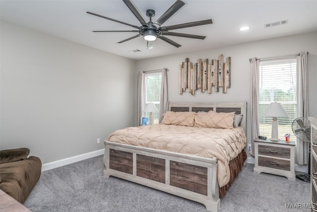 carpeted bedroom featuring multiple windows and ceiling fan